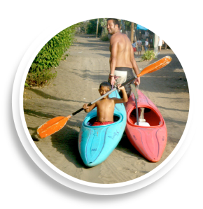 man dragging boy in canoe along dirt road